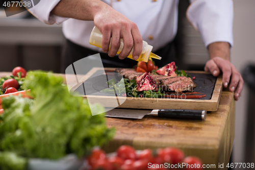 Image of Chef finishing steak meat plate