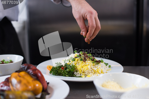 Image of Chef hands serving vegetable risotto