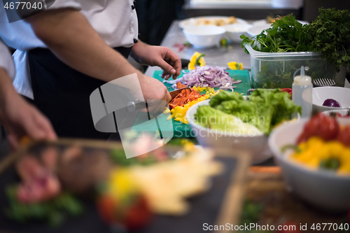 Image of Chef hands cutting fresh and delicious vegetables