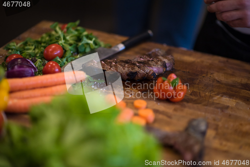 Image of closeup of Chef hands preparing beef steak