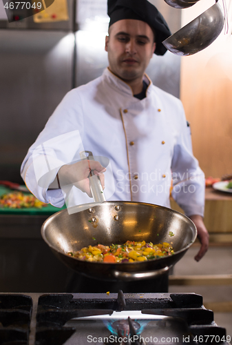 Image of chef flipping vegetables in wok