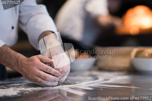 Image of chef hands preparing dough for pizza