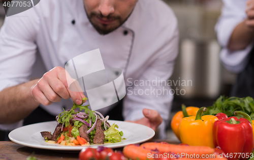 Image of cook chef decorating garnishing prepared meal