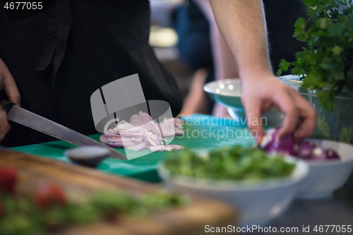 Image of Chef  hands cutting the onion with knife