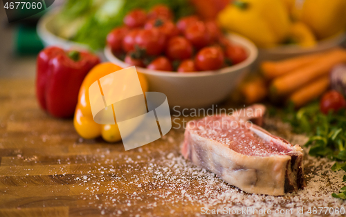 Image of Juicy slice of raw steak on wooden table