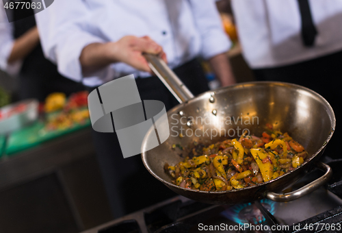 Image of chef flipping vegetables in wok