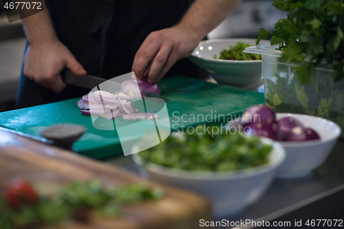 Image of Chef  hands cutting the onion with knife
