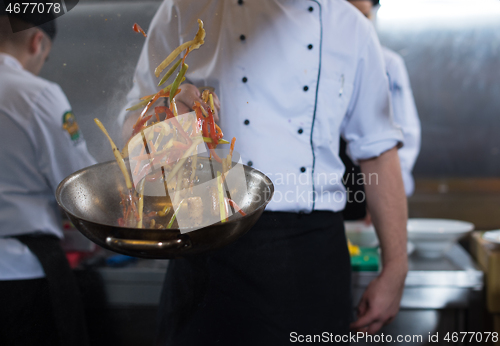 Image of chef flipping vegetables in wok