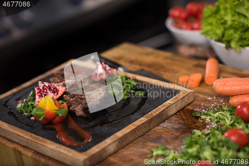 Image of Juicy slices of grilled steak on wooden board