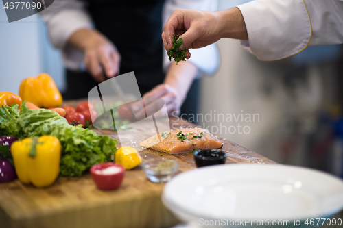 Image of Chef hands preparing marinated Salmon fish