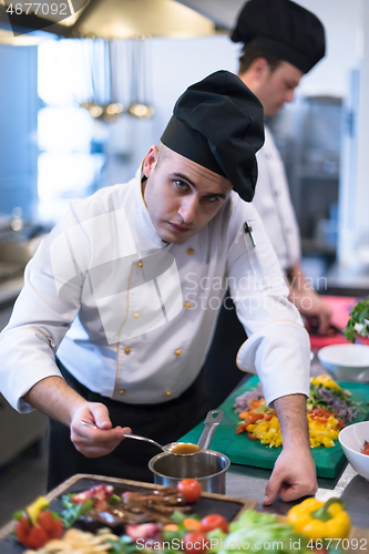 Image of Chef finishing steak meat plate