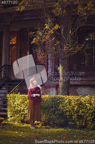 Image of Girl standing near old house