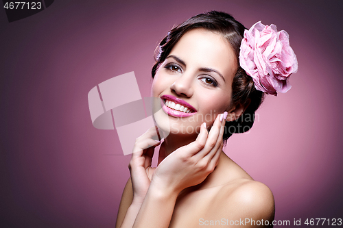 Image of beautiful girl with rose in hair