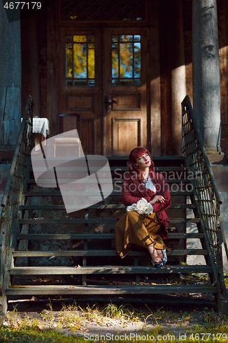 Image of Girl sitting on old house stairs