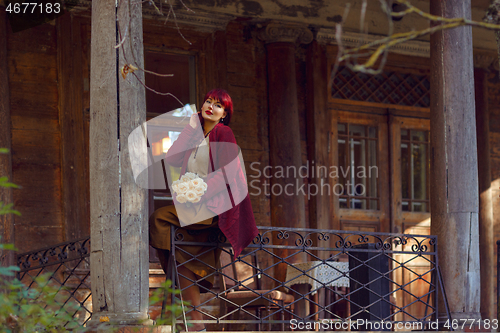 Image of Girl sitting on old house balcony