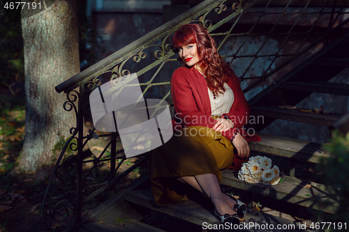 Image of Girl sitting on old house stairs