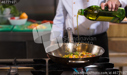 Image of chef flipping vegetables in wok