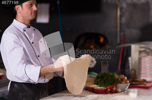 Image of chef throwing up pizza dough