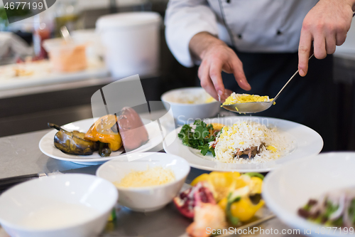 Image of Chef hands serving vegetable risotto