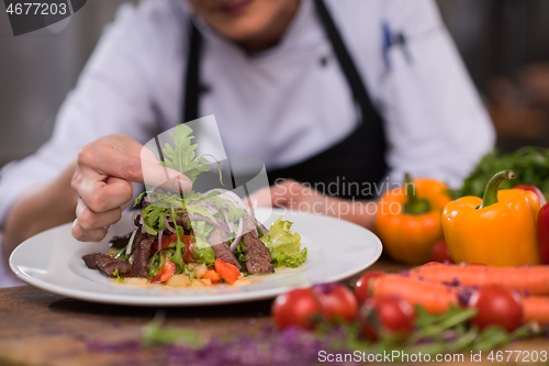 Image of cook chef decorating garnishing prepared meal