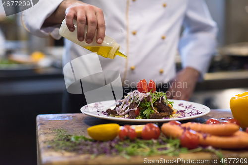 Image of Chef finishing steak meat plate