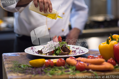 Image of Chef finishing steak meat plate