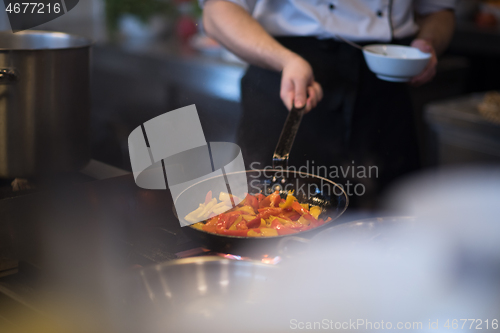 Image of chef flipping vegetables in wok