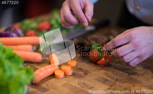 Image of closeup of Chef hands preparing beef steak