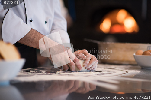 Image of chef hands preparing dough for pizza