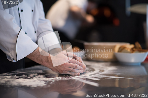 Image of chef hands preparing dough for pizza