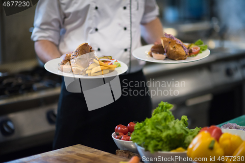 Image of Chef showing dishes of tasty meals