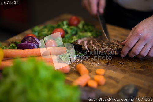 Image of closeup of Chef hands preparing beef steak