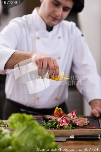 Image of Chef finishing steak meat plate