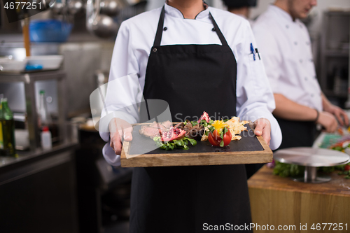 Image of female Chef holding beef steak plate