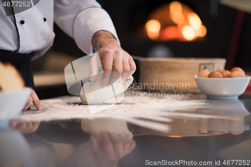 Image of chef hands preparing dough for pizza