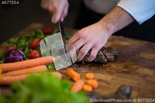 Image of closeup of Chef hands preparing beef steak