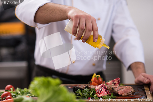 Image of Chef finishing steak meat plate