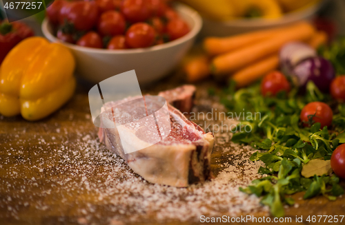 Image of Juicy slice of raw steak on wooden table