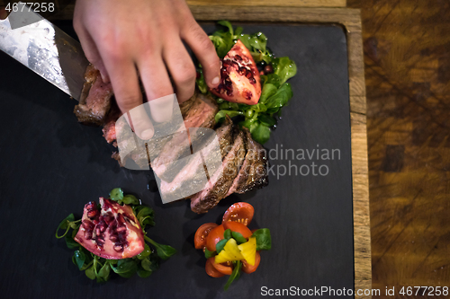 Image of top view of Chef hands serving beef steak
