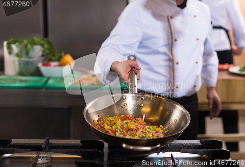 Image of chef flipping vegetables in wok