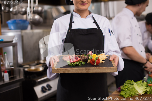 Image of female Chef holding beef steak plate