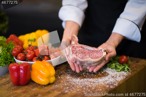 Image of Chef holding juicy slice of raw steak