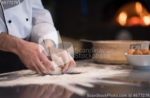 Image of chef hands preparing dough for pizza