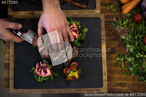 Image of top view of Chef hands serving beef steak