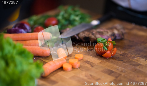 Image of Juicy slices of grilled steak on wooden board