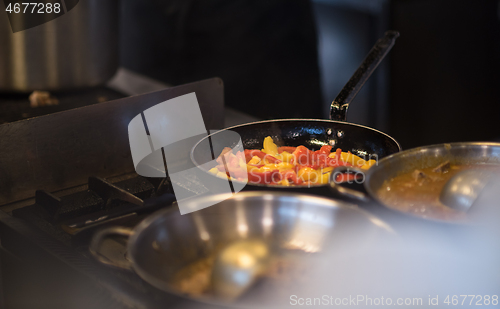 Image of chef flipping vegetables in wok