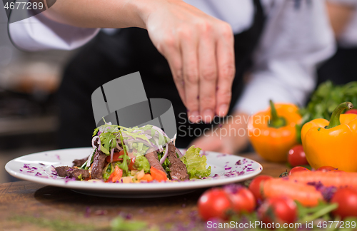 Image of cook chef decorating garnishing prepared meal