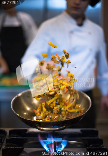 Image of chef flipping vegetables in wok