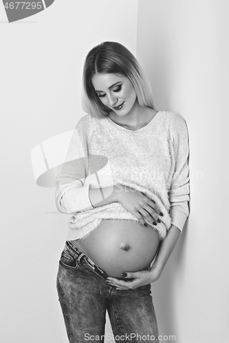 Image of Beautiful pregnant woman in jeans