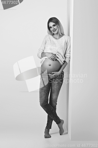 Image of Beautiful pregnant woman in jeans